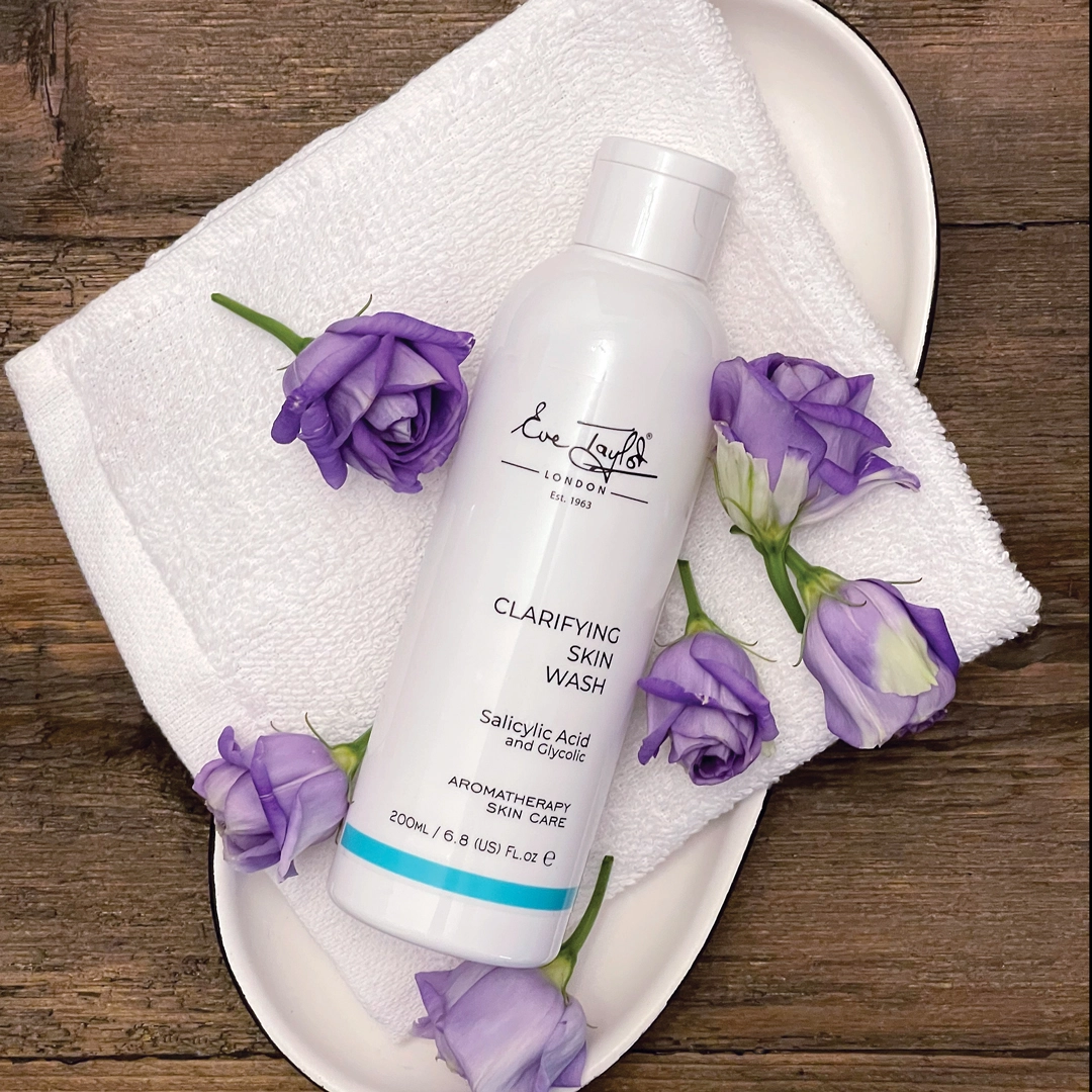 Eve Taylor Clarifying Skin Wash displayed on a towel with flowers